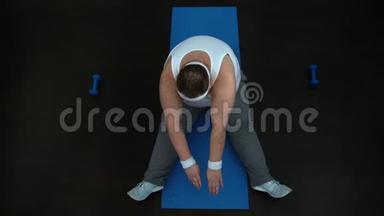 疲惫的超重男子在家锻炼后在垫子上伸展，减肥计划